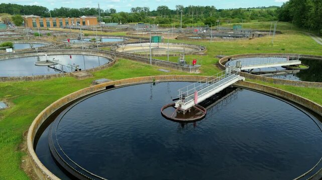 Close up aerial view of a circular clarifier tank and settling basin at a wastewater treatment and sewage works facility in the UK.
