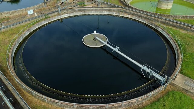 Close up aerial view of a circular clarifier tank and settling basin at a wastewater treatment and sewage works facility in the UK.