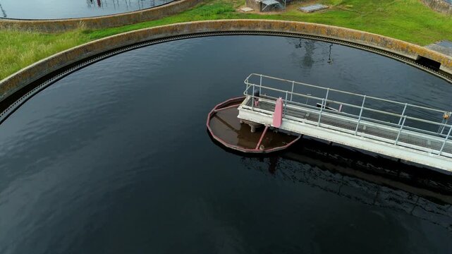 Close up aerial view of sewage treatment works circular clarifier tank with clean water in Hoddesdon, UK