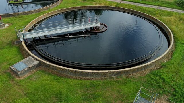 Close up aerial view of sewage treatment works circular clarifier tank with clean water in Hoddesdon, UK