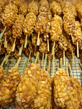 close-up shot of several Korean potato corn dogs, neatly stacked on a cooling wire rack