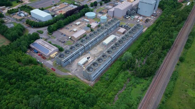Aerial view of a large energy production power plant with rows of rotating turbines visible on the generation house roof in Bedfordshire, UK.