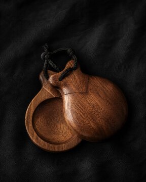 castanet. Traditional flamenco castanets resting on dark textured fabric. event programs, museum guides, designed for cultural heritage projects and event programs, elevates cultural identity.