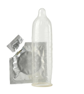 Unrolled clear condom standing next to torn foil wrapper