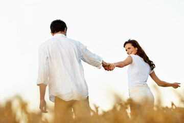 Obraz premium Couple, holding hands and outdoor in meadow on date, partner and support with care in nature. People, marriage and romantic stroll for healthy relationship, bonding and together with smile for love