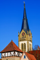 Obraz premium Der markante neugotische Turm der Evangelischen Stadtkirche über den Dächern der Altstadt von Möckmühl, Baden-Württemberg
