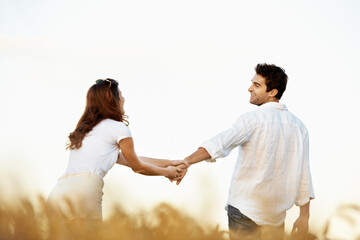Obraz premium Couple, happiness and man holding hands in meadow, partner and support with care in nature. Male person, smile and woman outdoor for relationship, bonding and together with love, space and walk