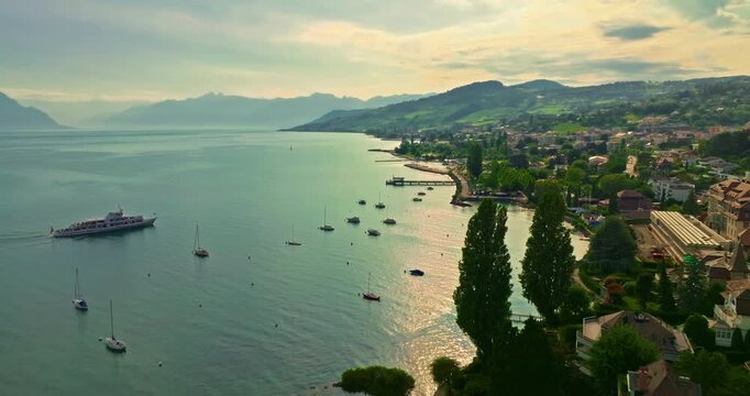 Establishing shot of swiss city Lausanne in summer day. Aerial view of the Switzerland city on the shores of Lake Geneva