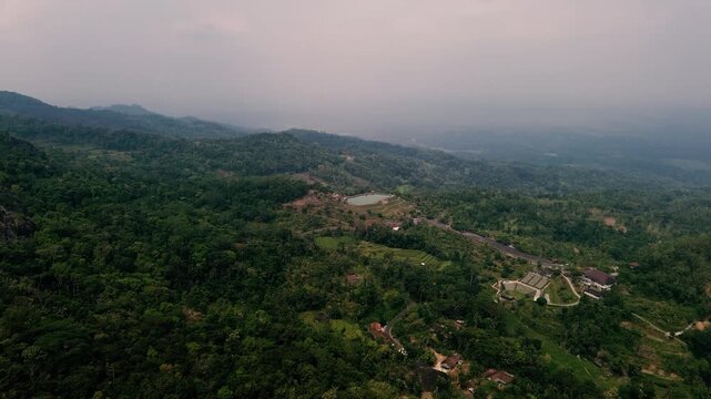 Aerial drone footage of Embung Nglanggeran, a scenic artificial reservoir located in the Ancient Nglanggeran Volcano area, Yogyakarta, Indonesia.