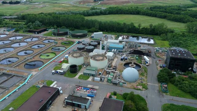 Aerial view of anaerobic digester tanks, biogas spheres, and sludge processing infrastructure at wastewater treatment works in Milton Keynes, UK.