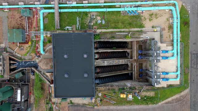 Aerial view of a massive Archimedes screw pump lifting wastewater at a sewage treatment works for urban sanitation, Milton Keynes, UK.