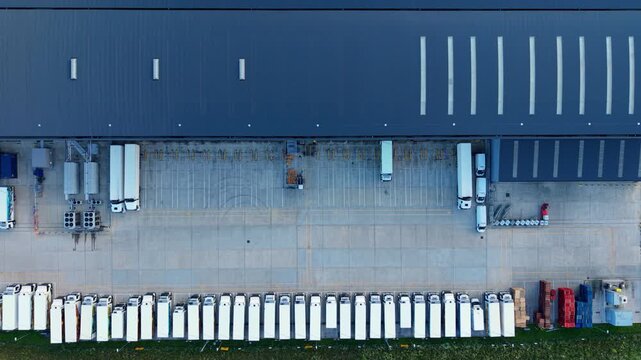 Top down aerial view of massive industrial distribution centres and parked HGVs in Biggleswade, UK