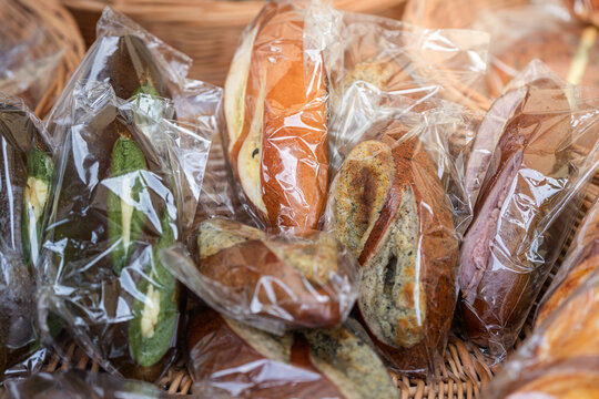 assorted wrapped stuffed pretzel breads displayed in wicker basket