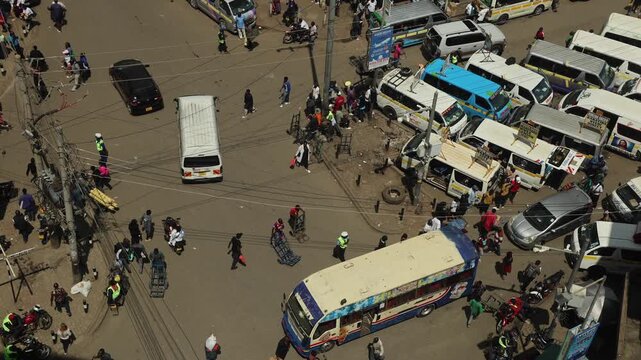 Nairobi, Kenya - 05 December 2024: View of a bustling street with matatus, buses, and pedestrians navigating through heavy urban traffic in the city center.