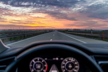 Fototapeta premium Highway view from car at sunset. Road travel and transport content.