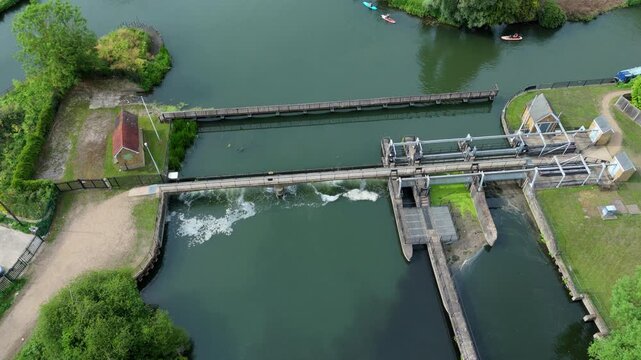 Aerial view of white water rushing over Feildes Weir on the River Lee Navigation for canal flood management near Hoddesdon, Hertfordshire, UK.