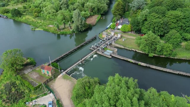 Aerial view of white water rushing over Feildes Weir on the River Lee Navigation for canal flood management near Hoddesdon, Hertfordshire, UK.