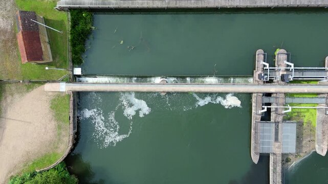Aerial view of white water rushing over Feildes Weir on the River Lee Navigation for canal flood management near Hoddesdon, Hertfordshire, UK.