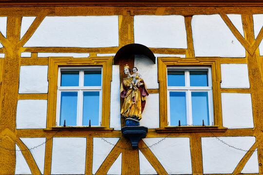 Historische Hausmadonna an einer traditionellen Fachwerkfassade in Forchheim, Bayern