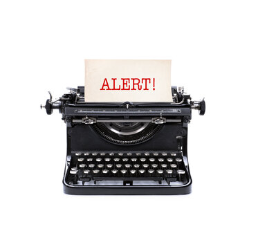 Alte analoge Schreibmaschine mit Briefblatt und der Notiz Alert