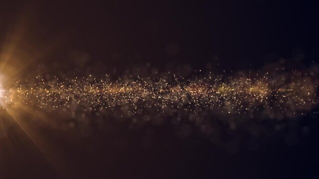 Luxury event background with glittering shiny gold stardust particles streaming across the frame. This golden special occasion background is ideal for events, award ceremonies and talent shows.