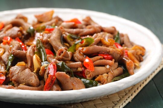 oseng usus ayam, a savory and spicy stir-fried chicken intestine dish cooked with chili peppers, garlic, shallots, sweet soy sauce, and aromatic spices.