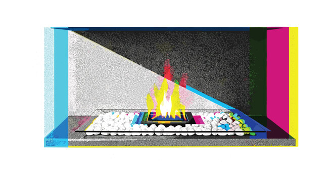 A modern minimalist indoor fireplace displays a vibrant multicolored flame rising from a bed of clean white pebbles set against a dark rectangular firebox structure.