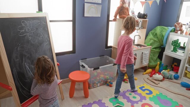 Girl places hand to forehead while standing on colorful number mat and facing another child by a chalkboard in a building; playful imagination.