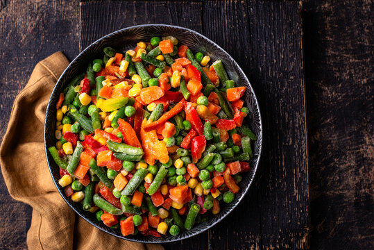 Frozen mix of vegetables on dark background