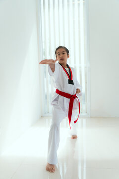 Young girl practices martial arts in a bright room during afternoon training session