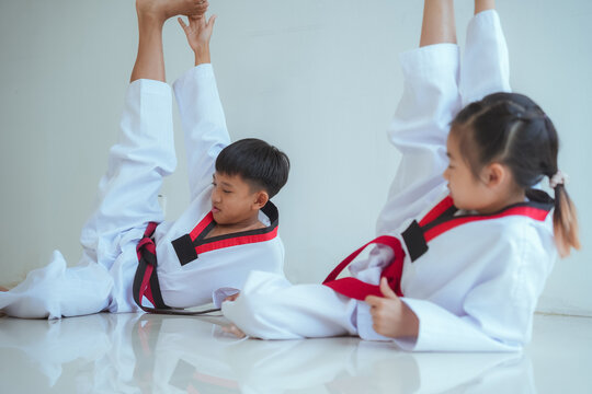 Kids practice taekwondo moves in training session at a martial arts dojo during afternoon class