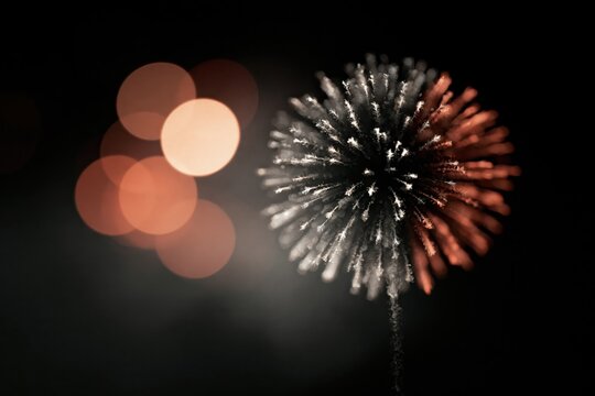 Fireworks display in night sky with bright colors and blurred lights during celebration event