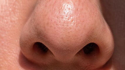 Fototapeta premium Close-up view of human nose with visible skin texture and natural pores detail