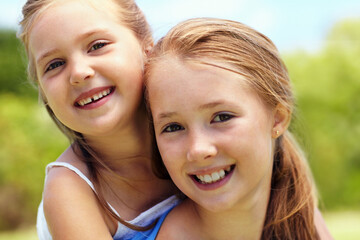 Fototapeta premium Portrait, girl or sisters with smile in nature for fun childhood, growth or support together in park. Happy, children or kids with embrace or piggyback for playful weekend, holiday or outdoor bonding
