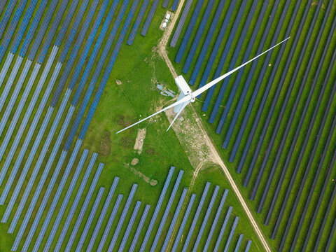 Aerial view of a massive hybrid solar and wind energy farm in rural England for net zero power resilience