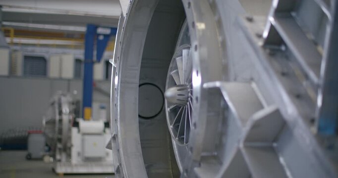 Close up view of a metallic radial turbine fan assembly inside a large industrial machine