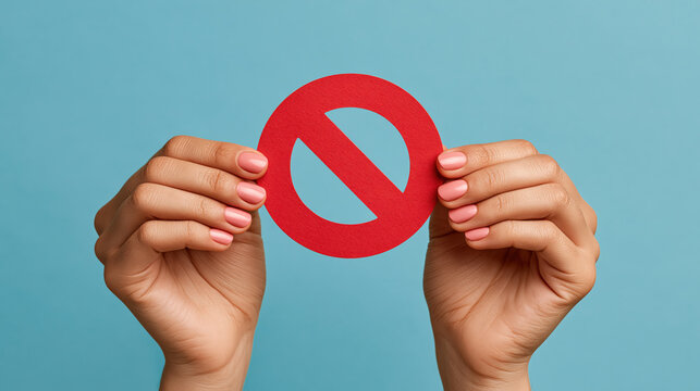 Close up of hands holding red prohibition sign for ban restriction warning stop message and simple safety communication