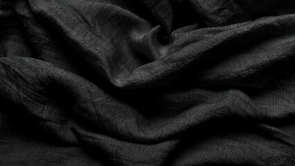black linen fabric background ripples softly in dark moody shadows creating organic texture for...