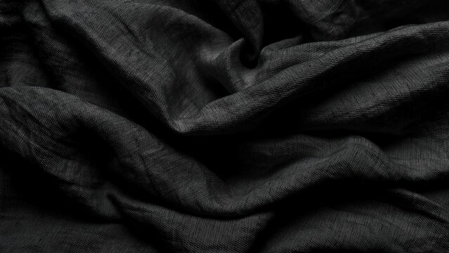 black linen fabric background ripples softly in dark moody shadows creating organic texture for minimalist design