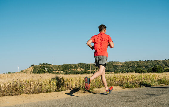 Man in red shirt running outdoor in nature