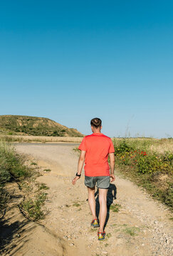 Man trail running outdoors under clear sky