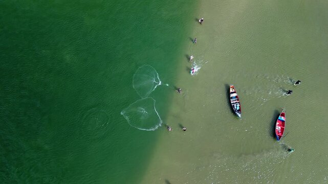 Fishing with dolphins, authentic fishing tradition in Brazil. Aerial view of the group of fishermen collaborating and fishing together with dolphins