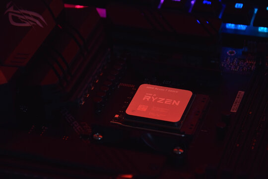 A close-up of an AMD Ryzen 7 5800X processor in a packaging box with backlit keyboards in the background.