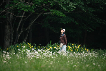 Obraz premium Woman meadow flower forest nature grass tree wildflower summer peaceful young woman walking through wildflower meadow near dark forest edge with calm expression and green natural scenery