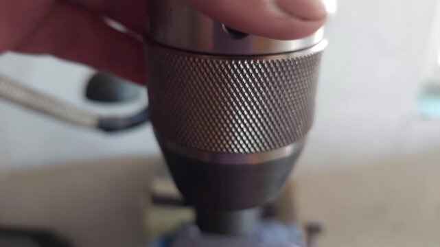 Close-up of worker hand tightening a metal drill chuck