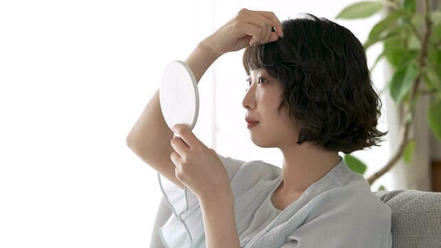 鏡を見ながら前髪を整える女性, Woman Adjusting Her Bangs While Looking in a Mirror