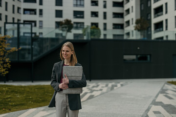 Fototapeta premium Businesswoman carrying laptop case walking in urban environment