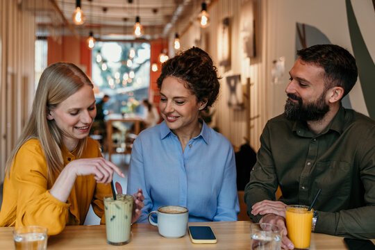 Friends enjoying drinks and conversation in coffee shop