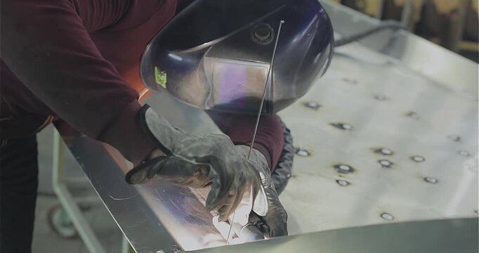 Production of an aluminum hull for a motorboat. Welding process. Close-up of welding an aluminum boat hull or aluminum alloys. Boat production. Production site. Welding shop