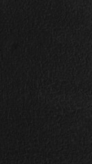 Fototapeta premium Dark textured black mobile wallpaper with a subtle, rough surface for a dramatic effect